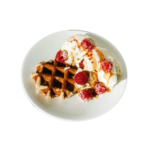 A White Plate Topped With Waffles and Ice Cream